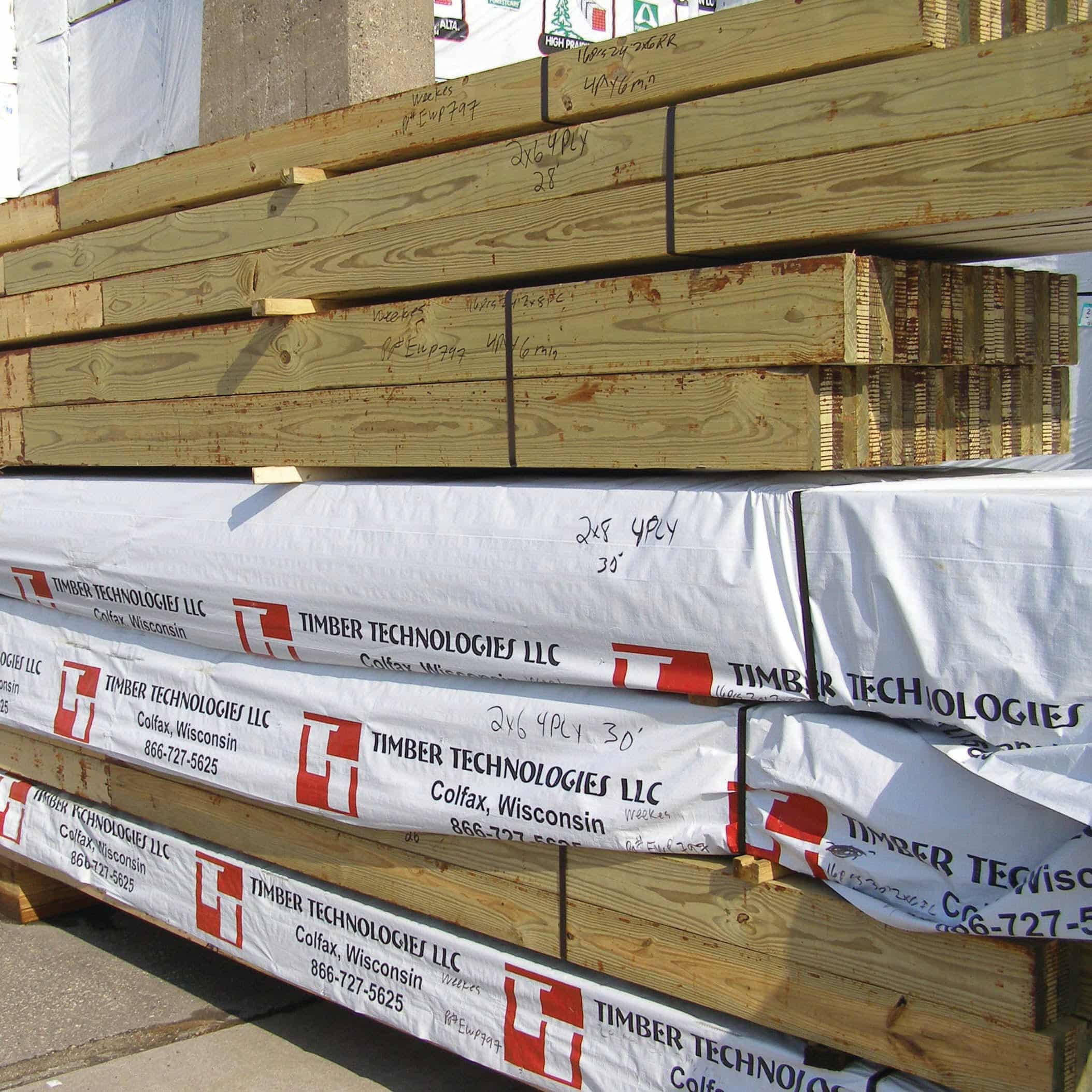 Glulam post frame columns by Titan Timbers stacked in a pile.